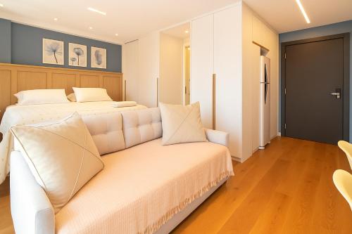 a bedroom with a white bed and a couch at 1306 - Luxuoso Studio BF - CWB Central - Com Garagem in Curitiba