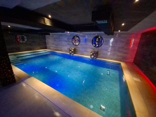 a swimming pool in a room with clocks on the wall at A2 Silver & SPA in Veliko Gradište