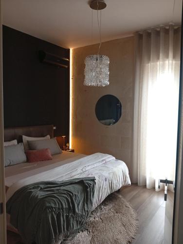 a bedroom with a large bed and a chandelier at CHEZMOI (da me) in Matera
