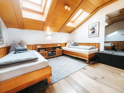 Duas camas num quarto com paredes e tectos em madeira em ALPINE Appartement 407 Schladming by globboard em Schladming