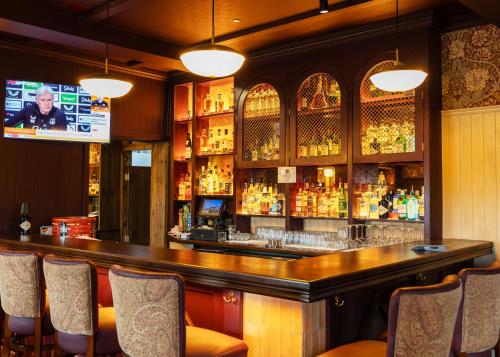 a bar with chairs and a television in a room at Hatton's of Garadice in Garadice