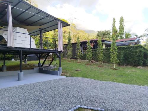 a view of a house with a pavilion in a yard at Osaglamping in Palmar Norte