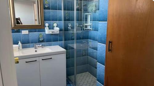 a blue tiled bathroom with a sink and a shower at Mains Rd 舒适双人间2张床2 in Brisbane
