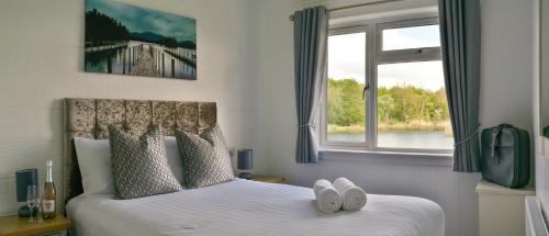 Un dormitorio con una cama con sábanas blancas y una ventana. en Silverwood Luxury Lodge Resort, 37 individual stunning properties, en Perth