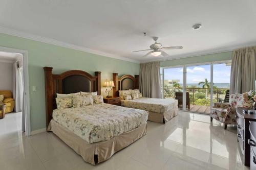 a large bedroom with two beds and a balcony at Beachfront - Best View 2BR condo - E422-2 in Palm-Eagle Beach