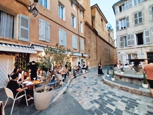 a group of people sitting at tables in a courtyard at Joli studio à Aix-en-Provence in Aix-en-Provence