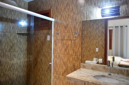 une salle de bain avec une douche avec un lavabo et un miroir dans l'établissement Pousada do amor, à São Miguel do Gostoso