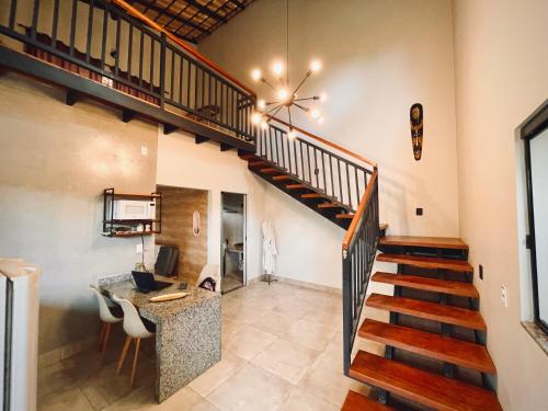 a room with a staircase and a desk with a computer at Claruá Chalés - LOFT CAJU- Lofts românticos em Cavalcante 5m do centro in Cavalcante