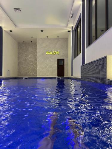 a swimming pool in a building with a sign on the wall at Perla Dacilor in Grădiştea de Munte