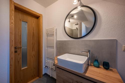 een badkamer met een witte wastafel en een spiegel bij Apartmány Bobrík in Liptovský Mikuláš