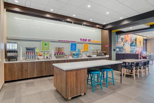 un restaurante con barra y taburetes en una cafetería en Tru By Hilton Gastonia, en Gastonia