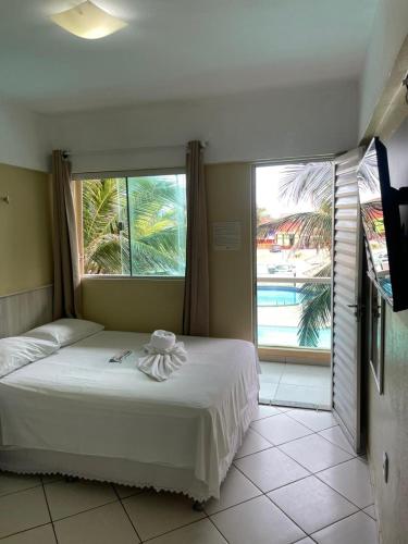 a bedroom with a bed and a view of a pool at Hotel Concha do Mar in Salinópolis