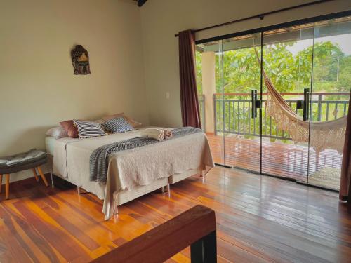 a bedroom with a bed and a large window at Claruá Chalés - LOFT CAJU- Lofts românticos em Cavalcante 5m do centro in Cavalcante