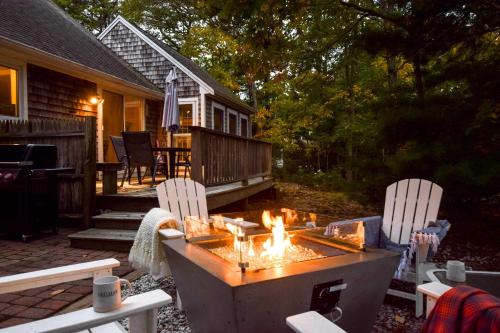 un patio con 2 sillas y una hoguera en 5-Mins to Forest Beach Dog Friendly, en Chatham