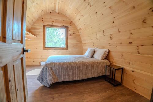1 dormitorio en una cabaña de madera con 1 cama en The Hobbit tiny house dogfriendly, en Saint-Alexis-des-Monts