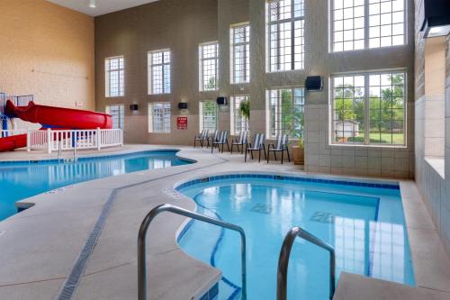 a swimming pool with a slide in a building at Best Western Premier Bridgewood Hotel Resort in Neenah