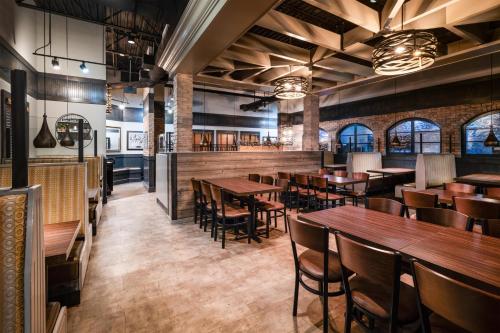 a restaurant with wooden tables and chairs at Best Western Premier Bridgewood Hotel Resort in Neenah