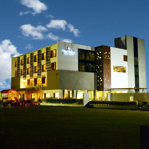 a building with a lit up sign in front of it at The Divine Resort Somnath in Somnath