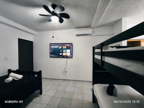 ein Schlafzimmer mit einem Bett und einem Deckenventilator in der Unterkunft sunrise in Cancun in Cancún