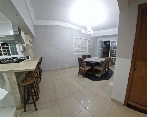 a kitchen and dining room with a table and chairs at Casa da Rosa in Goiânia