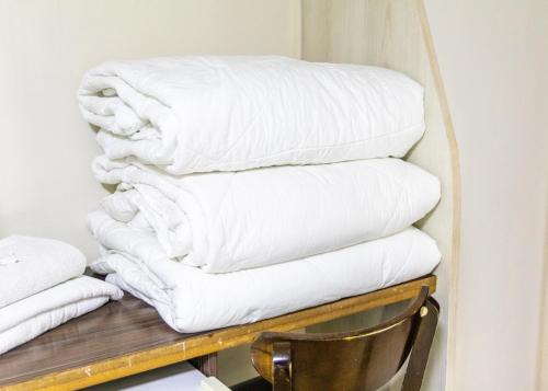 アレグレテにあるHotel Alegreteの木棚に白いタオルを積み重ねる