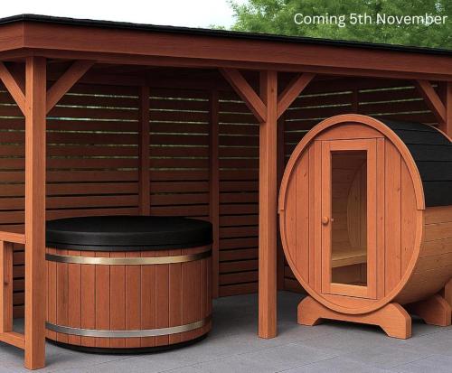 a wooden gazebo with a stool in front of it at Luxury Waterfront Retreat I Deluxe Lodge I Private Hot Tub & Sauna in Belturbet