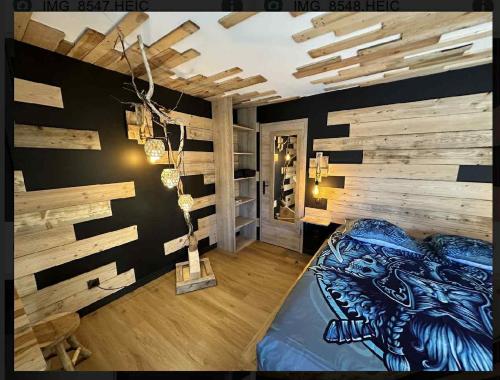 a room with a bed and a wooden wall at le valhalla odin in Forges-les-Eaux