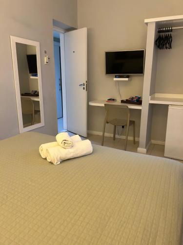 a hotel room with a bed with a towel on it at Hotel Petit Village Icaraí in Niterói