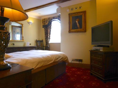 a bedroom with a bed and a flat screen tv at Villare Hitchin Town Centre in Hitchin