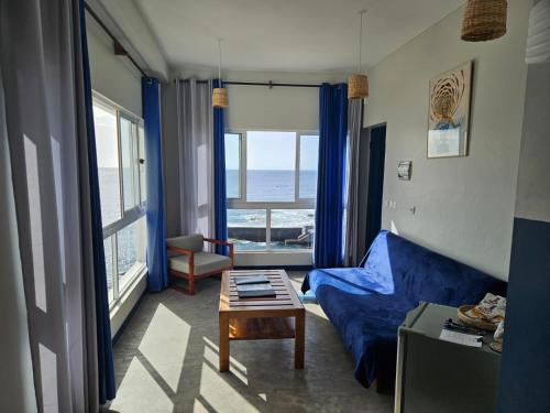 a living room with a blue couch and a table at kasa Tambla in Ponta do Sol