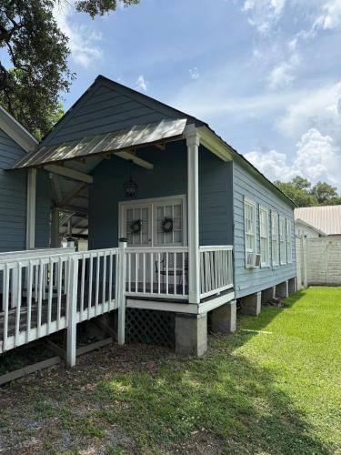 a blue house with a porch and a white railing at Courtyard by Ravens Keep in Jackson