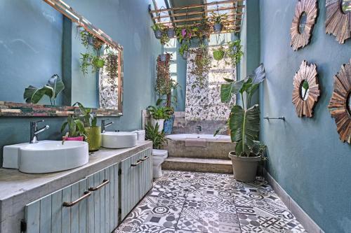 une salle de bain avec deux lavabos et une baignoire avec des plantes dans l'établissement Veranda House Boutique Accommodation, à Midrand