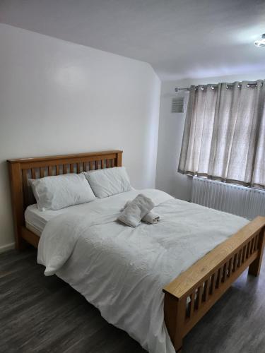 a bedroom with a large bed with a wooden headboard at 5 minutes from station and 1 minute to A13 in Dagenham Dock