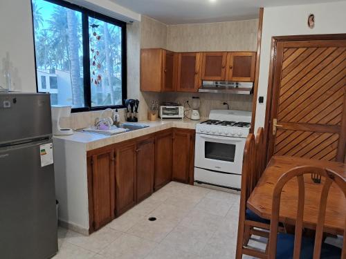 eine Küche mit Holzschränken und einem weißen Herd mit Backofen in der Unterkunft Apartamento con vista al mar Tucacas in Tucacas