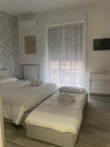 een slaapkamer met twee bedden en een raam bij Sogni di Stelle in Salerno