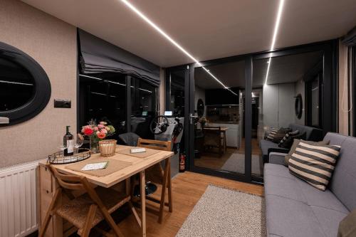 a living room with a table and a couch at Houseboat Pałuki in Sobiejuchy