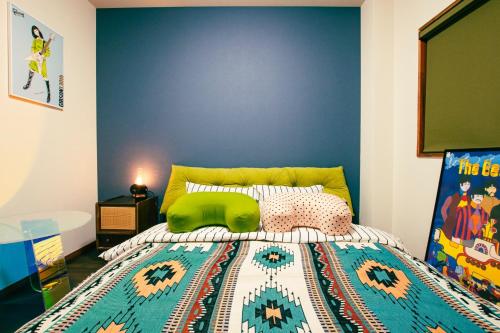 a bedroom with a bed with a blue accent wall at MusicInn Matoya - Vacation STAY 62103v in Sumoto