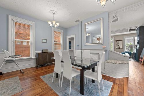 una sala da pranzo con un tavolo di vetro e sedie bianche di High Street Hideaway - For 8 a Milo