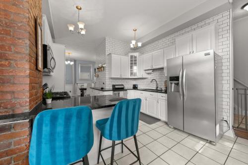 una cucina con 2 sedie blu e un frigorifero di High Street Hideaway - For 8 a Milo