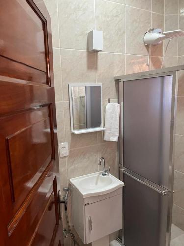 a small bathroom with a sink and a mirror at Casa Mar-A-Lagoa in São Pedro da Aldeia