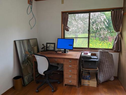 un bureau avec un bureau avec un ordinateur et une fenêtre dans l'établissement Villa Mountainman - Vacation STAY 69075v, à Ichijuku