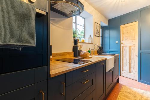 a kitchen with blue cabinets and a window at Bishy Hill Town House in York in York