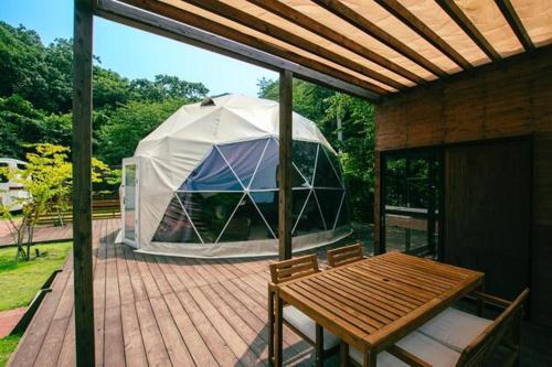 ein Zelt auf einem Deck mit einem Holztisch in der Unterkunft Yura Green - Vacation STAY 73976v in Yura