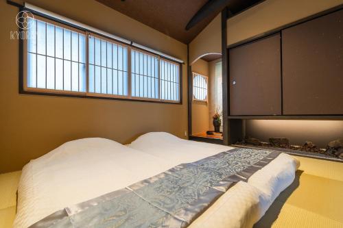 ein Schlafzimmer mit einem großen Bett und zwei Fenstern in der Unterkunft Jinglan-Kikyo Residence - Vacation STAY 09402v in Kyōto