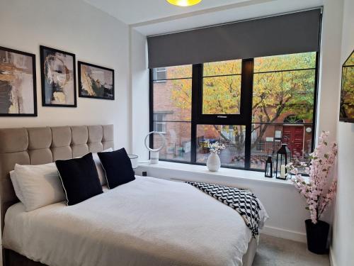 a bedroom with a bed and a large window at 34 Cuppin Street - luxury city centre apartment! in Chester