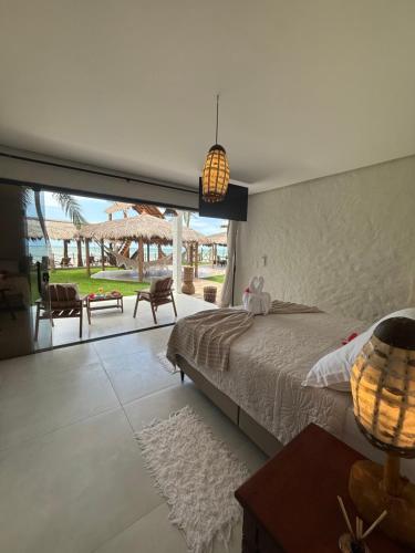 a bedroom with a large bed and a large window at Eco Pousada Paraíso Casamar in São José da Coroa Grande