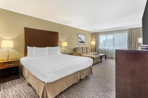 a hotel room with a large bed and a couch at Best Western Plus Garden Court Inn in Fremont