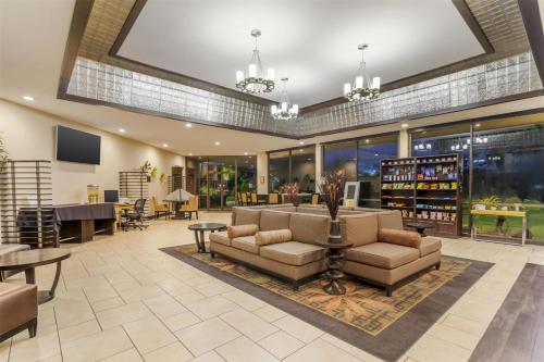 a large lobby with couches and tables and windows at Best Western Plus Garden Court Inn in Fremont