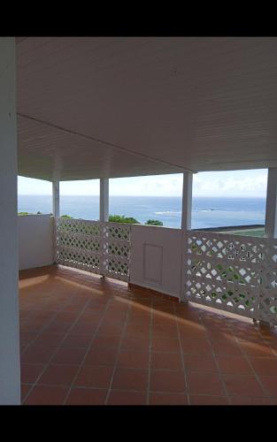 a view of the ocean from the balcony of a house at Les jardins de VALENTIN 2 in Le Gosier