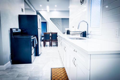 a white kitchen with a sink and a refrigerator at Perfect 6BR Stay Near Niagara Falls & Attractions in Niagara Falls